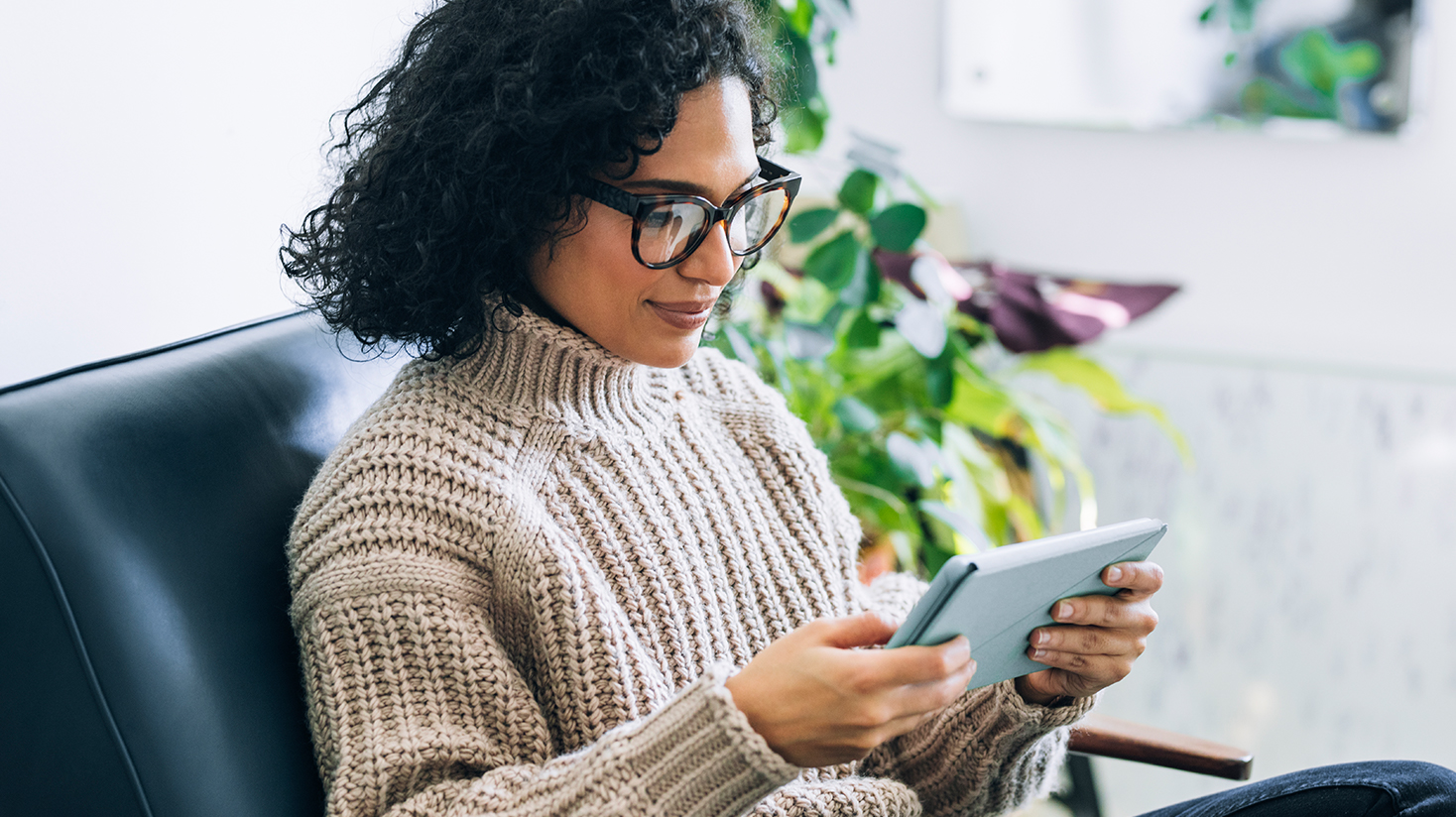 woman relaxing on the couch while looking at her ipad