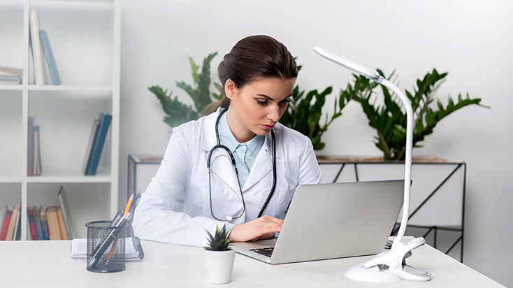 focused female medical professional using laptop