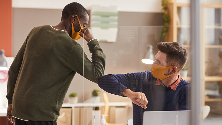 Coworkers with face masks elbowing each other