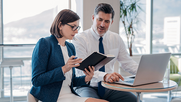 Man and woman in the office looking at a laptop