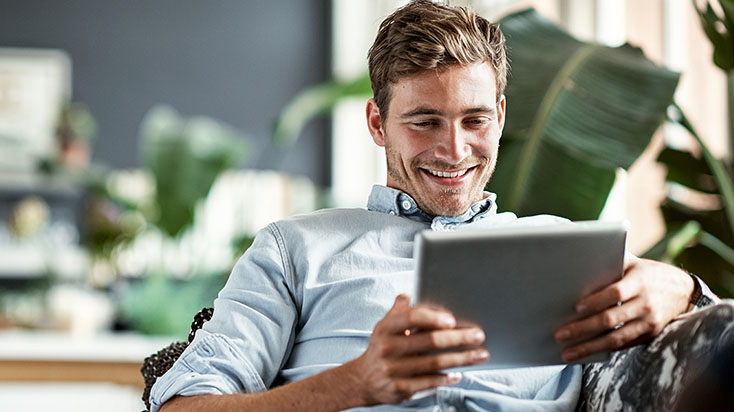 Young man smiling while look at a tablet