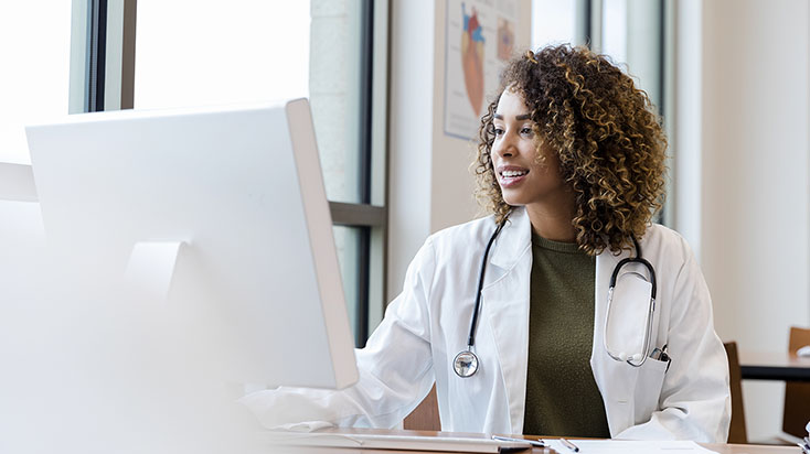 Medical professional smiling looking at computer