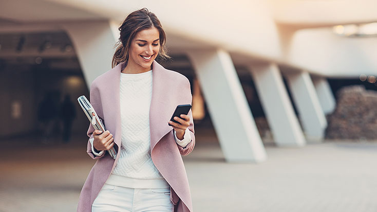 Business woman smiling while looking at her phone