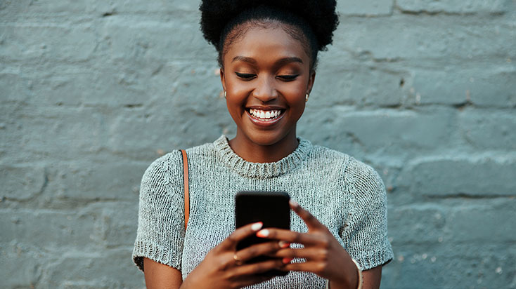 happy young woman texing on her phone