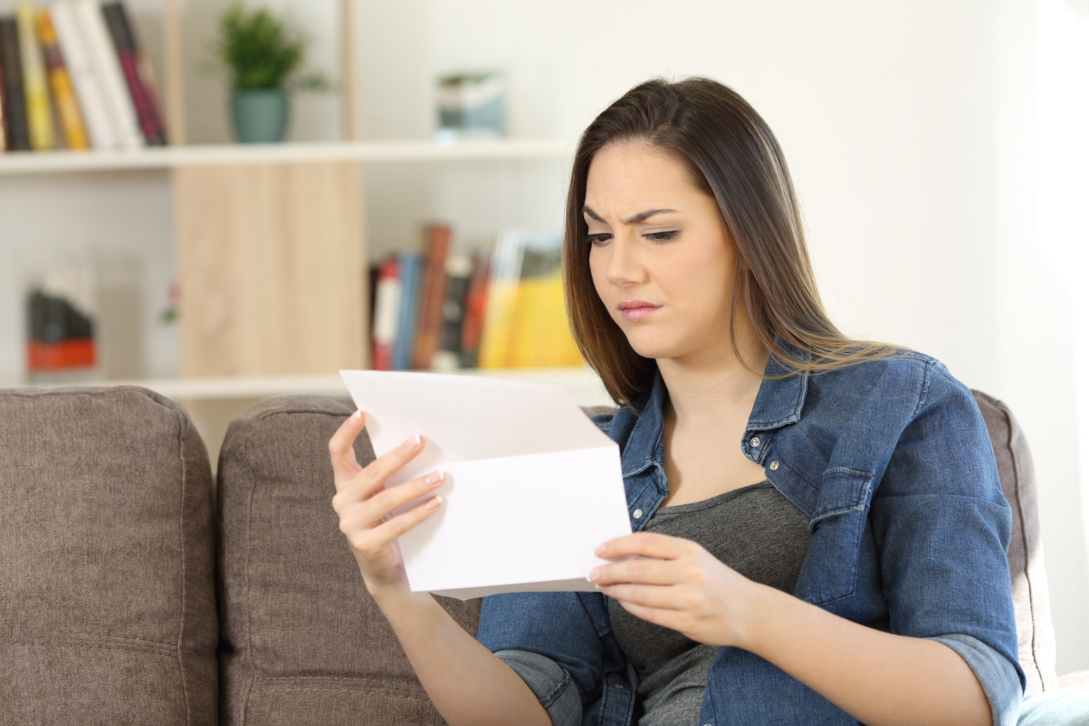 Suspicious female reading a letter at home